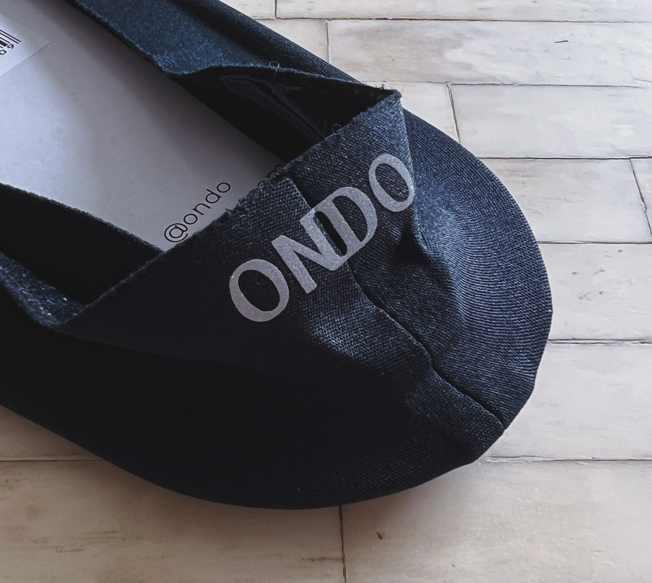closeup of black ondo sock heel on white tile table