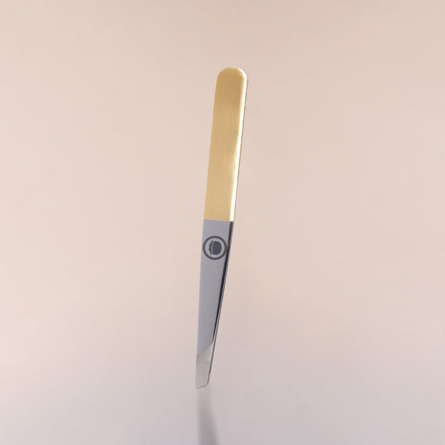 The slant tip Beardbrand Tweezers with two-tone stainless steel and the Beardbrand circle logo against a neutral background.