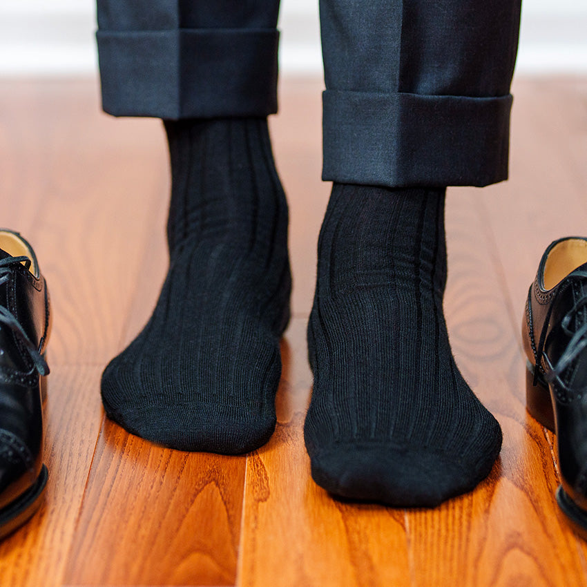 black dress socks and charcoal slacks with black oxfords on hardwood floor