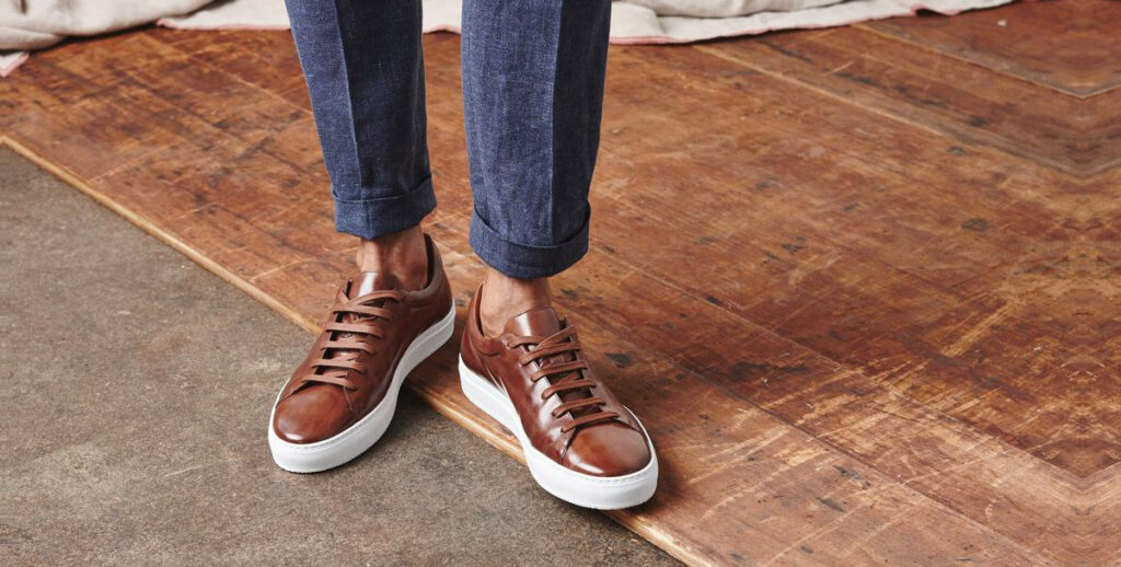 closeup of brown leather sneakers and blue pants